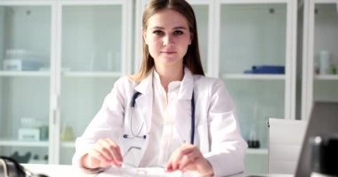 Klinikte elinde gözlük olan genç bir doktorun portresi. Sağlık sigortası ve hizmetleri
