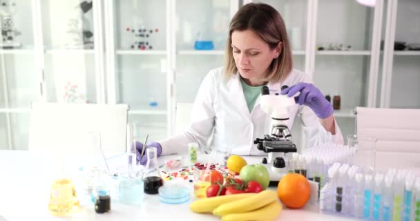 Женщина Ученый Микроскопом Пробирками Изучает Большое Количество Фруктов Овощей Лаборатории — стоковое видео