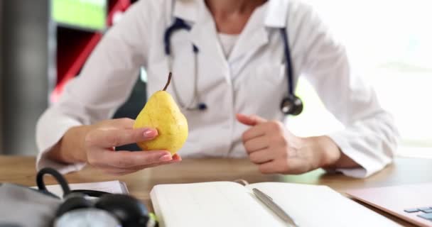 栄養士は新鮮な有機梨と親指を持っています 健康的な食事のアドバイスとビタミン — ストック動画