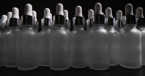 黒を背景にピペット付きの空のボトルの多くの数 化粧品や医薬品を保管するために設計されたボトル — ストック動画