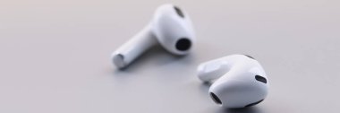 Gri arka planda kablosuz beyaz bluetooth kulaklıklar. Müzik dinlemek için kulaklık