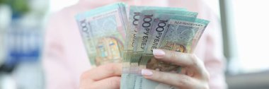 Kadınların elinde 100 ruble Belarus banknotları var. Belarus kavramında Ruble enflasyon ve yükselen fiyatlar