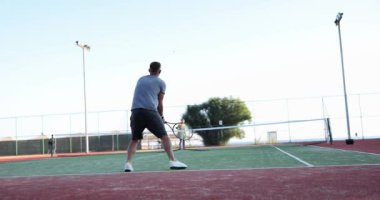 Tennis player hits ball on outdoor tennis court. Tennis game