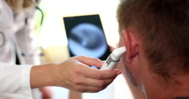 Otolaryngologist examines patient ear with digital otoscope. Hearing test and ear inflammation treatment