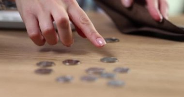 Woman hand counts coins on table closeup. Financial problems crisis and inflation and poverty