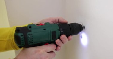 Daire duvarında kablosuz matkapla vida delmek. Daire yenileme için sondaj aracı