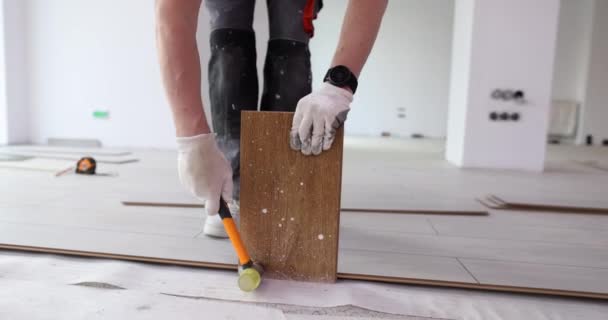 男性手戴白色手套 用橡胶木槌敲击 铺设新的层压板 — 图库视频影像