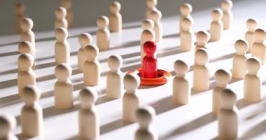 Ahşap insan heykelleri arasında kırmızı bir şekil var. Bireysellik, eşsizlik, liderlik ve insanları kurtarmak.