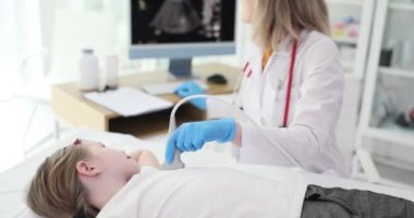 Doktor çocuğa yakın plan bir kalp ultrasonu yaptırıyor. Vasküler hastalıkların teşhisi, yavaşlama