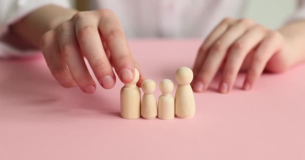 Vrouwelijke Handen Houten Poppen Een Roze Achtergrond Close Het Concept — Stockvideo