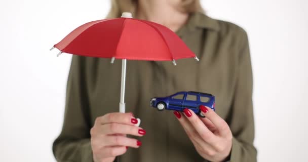 Una Mujer Negocios Sostiene Paraguas Rojo Sobre Coche Juguete Primer — Vídeos de Stock