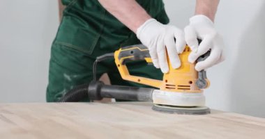 Erkek eller, tahtadaki öğütme makinesini hareket ettirir. Yakın plan. Marangozlar, tamir için hazırlık.