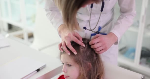 医者は少女の頭の上で髪に触れます クローズアップ トリコロジスト ライス検索 スローモーション — ストック動画