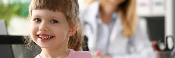 Πορτρέτο Του Μικρού Χαμογελαστού Κοριτσιού Στο Παρασκήνιο Κάθεται Γιατρός Υπηρεσίες — Φωτογραφία Αρχείου