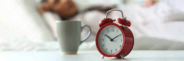 10時位置に赤い目覚まし時計と眠っている女性 穏やかな睡眠と遅い上昇の概念 — ストック写真