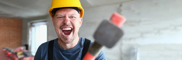 戴头盔的建筑工人拿着大锤和尖叫声 工程师对生产问题和团队中的欺侮感到愤怒 — 图库照片