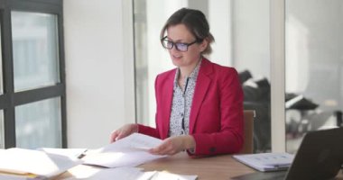 Gülümseyen iş kadını ofiste belgelerle çalışıyor. Belge ile başarılı bir yönetici