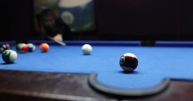 Kadın oyuncu beyaz topa vurdu ve cebine vurdu. Aktif kadın bilardo turnuvasını seviyor.