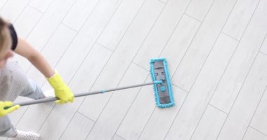 Kadın yerleri plastik paspasla yıkıyor. Ev veya ofis temizliği kavramı