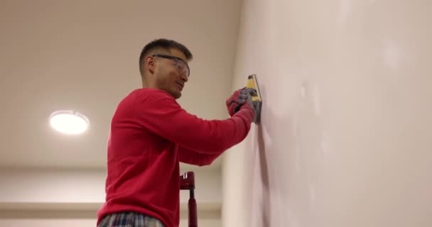 Stukadoor Gladstrijkt Muur Met Schuurpapier Trapladder Malen Muren Putten Repareren — Stockvideo