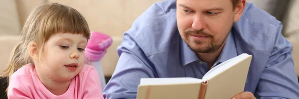 Pappa Läser Bok För Dottern Som Håller Smartphone Liggande Golvet — Stockfoto