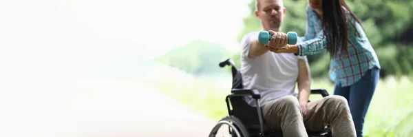 Fyzioterapeutka Pomáhá Postiženému Muži Invalidním Vozíku Zvednout Váhu Paže Parku — Stock fotografie