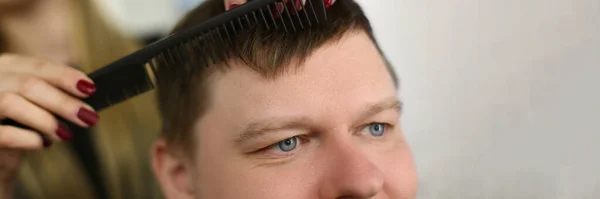 美容師ははさみと黒い櫛で髪をカットします バーバーショップサロンに座って満足した顧客の男 — ストック写真