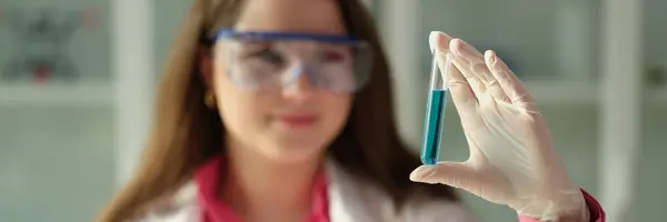 化学实验室的密闭中 女科学家化学家拿着蓝色液体试管 生产洗涤剂和化妆品的概念 — 图库照片