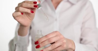 Güzel kadın elleri cilt bakımı ya da serum döker. El bakımı ve nemlendirici