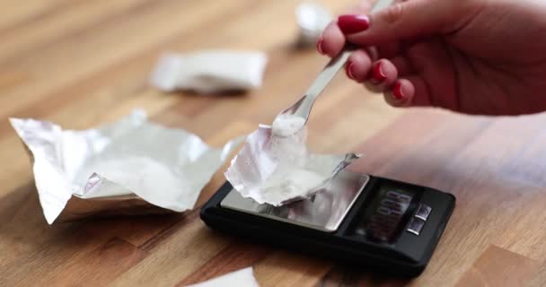 女性の手は スケールを使用して箔のシート上に白い粉体を量ります 違法薬物をスプーンで梱包する女 — ストック動画