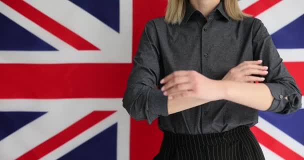 Женщина Уверенно Скрещивает Руки Перед Британским Флагом Получение Британского Гражданства — стоковое видео