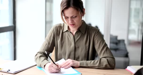 美しい女性マネージャーはオフィスでノートブックに書き込みます 業務計画書及びTo Doリスト — ストック動画