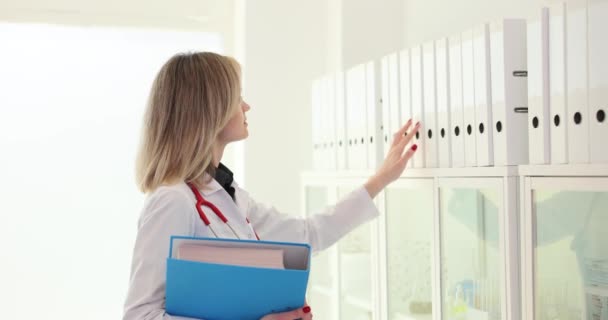 Médico Femenino Recoge Aglutinante Anillo Blanco Estante Enfermera Uniforme Médico — Vídeo de stock