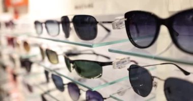 Mağazadaki raflarda moda güneş gözlükleri var. Kaliteli güneş gözlüğü seçimi
