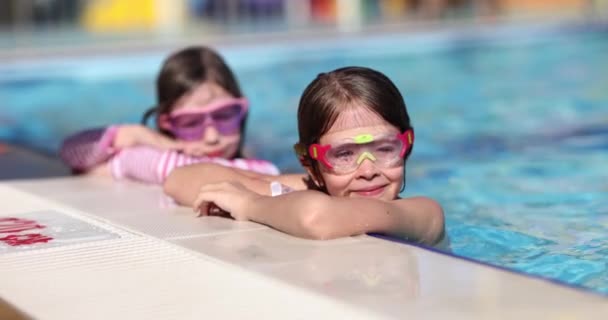 可爱的小女孩戴着粉色眼镜面具在游泳池里玩耍 儿童暑期游泳池度假 — 图库视频影像