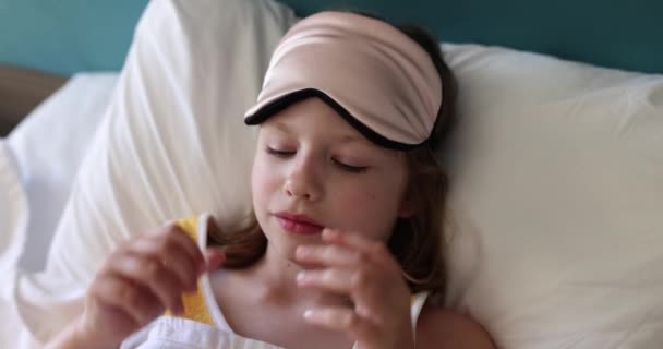 女孩在床上戴上睡眠面具 婴儿睡眠和舒适 — 图库视频影像