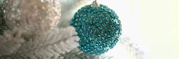 蓝白相间的圣诞球挂在白雪覆盖的云杉树枝上 圣诞树装饰概念 — 图库照片