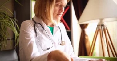Çok çalışan yorgun bayan doktor ofiste oturuyor. Tıpta fazla mesai