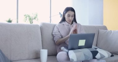 Evde dizüstü bilgisayarla çalışan heyecanlı bir kadın. Raporlarda uzak çalışma hatası ve serbest yazar kavramının son teslim tarihi