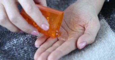 Kadın sarı kapsülleri omega-3 ile dolduruyor. Kız balık yağı konseptini alıyor.