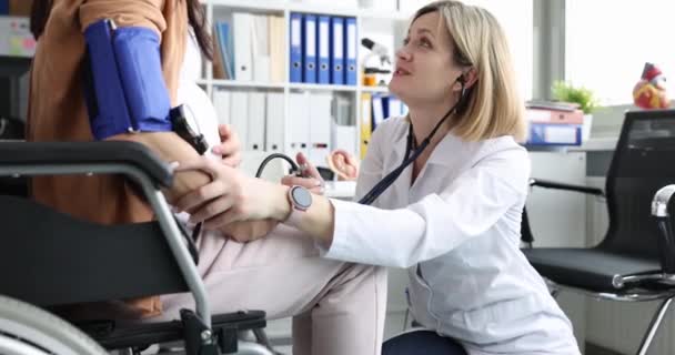 妊婦は医務室で車椅子に座っている 聴診器で赤ちゃんのハートビートを聞く — ストック動画