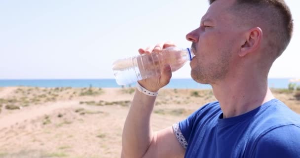 Joven Bebiendo Agua Por Mar Botella Plástico Película Verano Concepto — Vídeo de stock