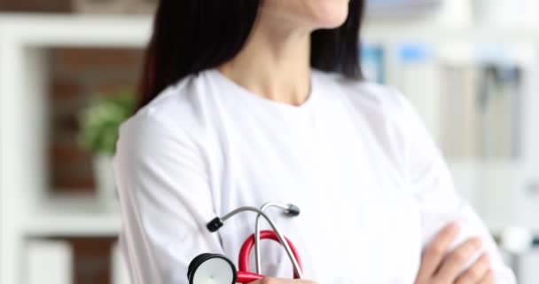 笑顔の女性医師クリニックで赤い聴診器を保持4K映画スローモーション 医者の職業概念 — ストック動画