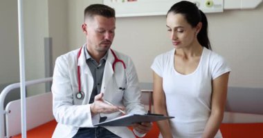 Genç doktor, tıbbi muayenenin sonuçlarını hasta 4K filmiyle tartışıyor. Klinik konseptinde tıbbi bakım