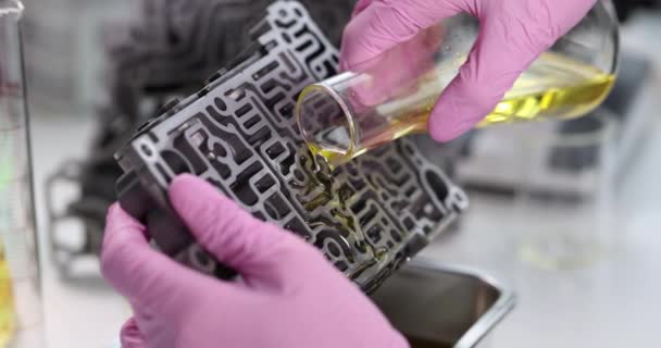 변속기를 수리하기 위하여 장갑을 실험실에서 기계에 붓는다 — 비디오