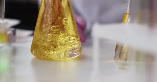 Flüssigkeit Wird Einem Kolben Mit Gelber Öliger Flüssigkeit Beigemischt Der — Stockvideo