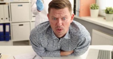 Doktor proktolog steril eldiven takıyor ve rektum 4K filminde hastayı muayene ediyor. Hemoroit konsepti teşhisi ve tedavisi