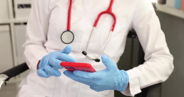 医師保護医療手袋携帯電話4K映画の画面から情報を読み取ります 携帯電話の概念のための近代的な医療アプリケーション — ストック動画