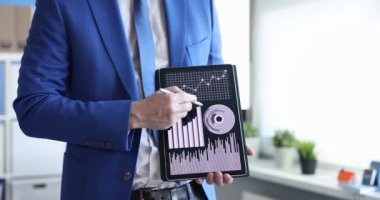 İşadamı dijital tablet 4K filminde çizelge ve diyagramları gösteriyor. İş eğitimi kavramı