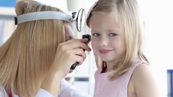 头部反射镜检查小女孩的耳朵用耳镜4K胶卷 儿童听觉障碍的诊断与治疗 — 图库视频影像